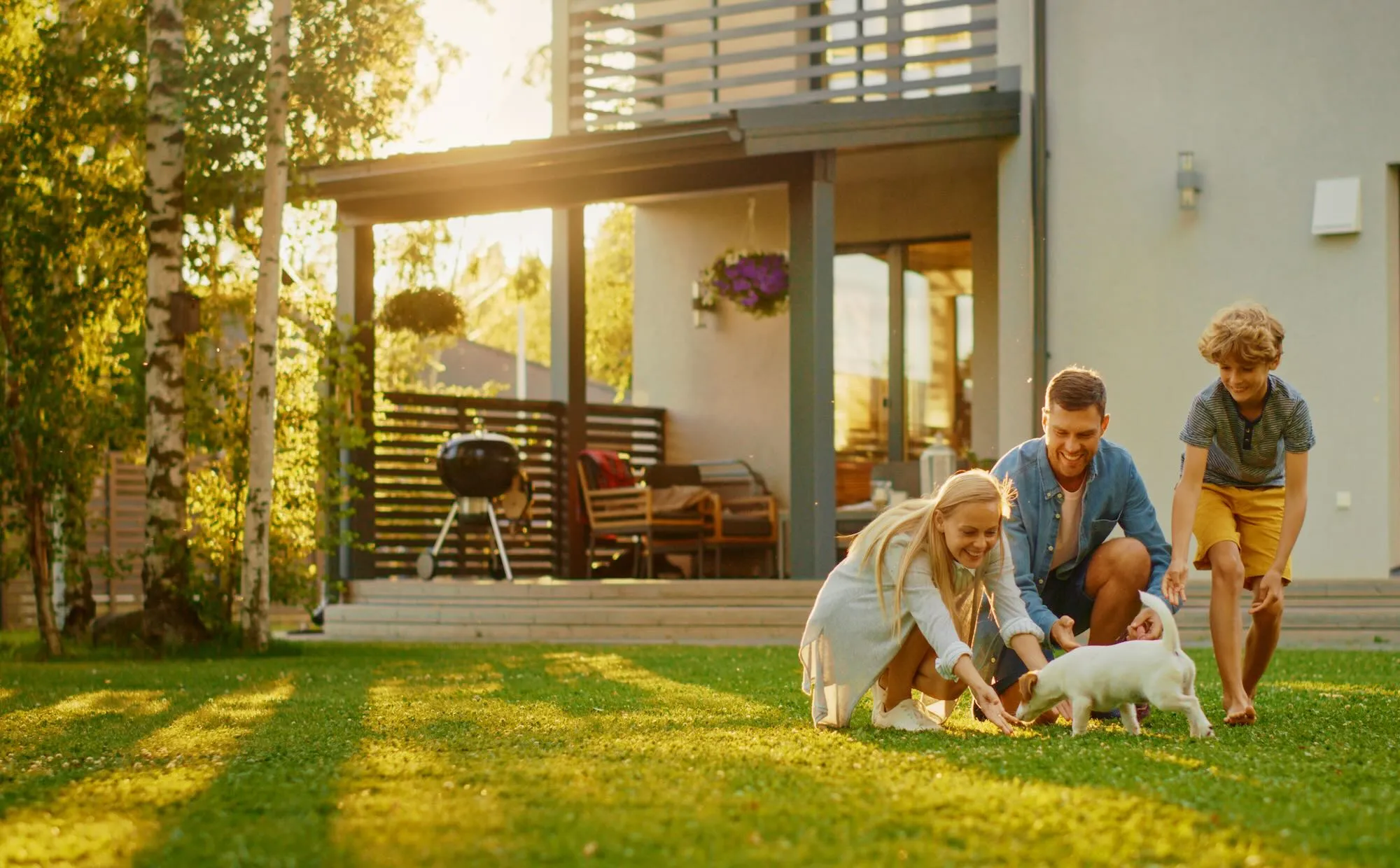 happy family playing with their dog at their backyard
